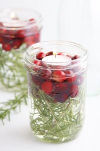 glass jar with pine needles, cranberries and small candle arrange inside click for image source article